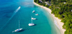 Aerial view of five boats anchored in the water at a beach in Barbados.