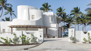 Luxury villa on the East Coast of Barbados with white walls, unique architecture, and palm trees in the background
