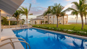 Pool view of a luxury villa in Barbados with palm trees in the background