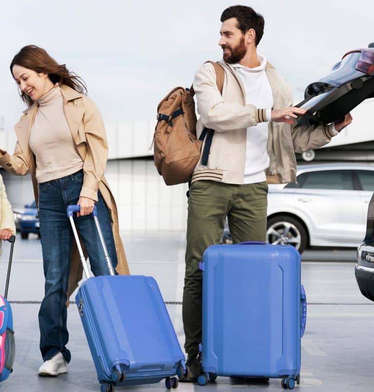 a family of 3 standing in an airport carpark taking suitcases from the trunk of a car. Heading on a direct flight to Barbados